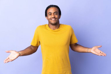 Örgülü genç Afrikalı Amerikalı adam mor arka planda izole edilmiş mutlu ve gülümsüyor.