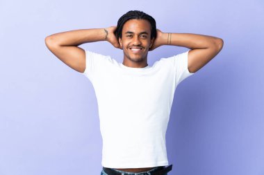 Örgülü genç Afrikalı Amerikalı adam, mor arka planda izole edilmiş gülüyor.