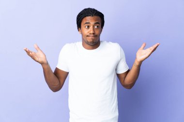 Örgülü genç Afrikalı Amerikalı adam mor arka planda izole edilmiş şüpheli hareketler yapıyor.