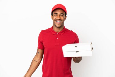 Afro-Amerikalı pizza teslimatçısı izole edilmiş beyaz duvarın üzerinden pizza kutuları topluyor.