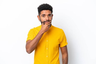 Genç Brezilyalı bir adam beyaz arka planda soyutlanmış düşünüyor.