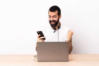 Tele-pazarlamacı beyaz adam kulaklıkla çalışıyor ve laptopuyla şaşırdı ve bir mesaj gönderiyor..