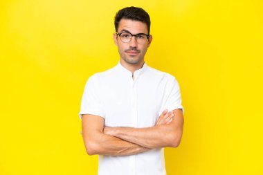 Izole sarı arka plan üzerinde genç yakışıklı adam üzgün duygu