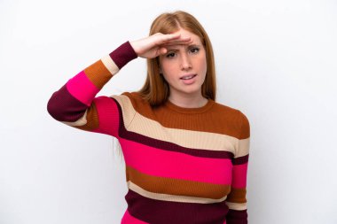 Genç kızıl saçlı kadın, beyaz arka planda izole edilmiş. Bir şeye bakmak için uzaklara bakıyor.