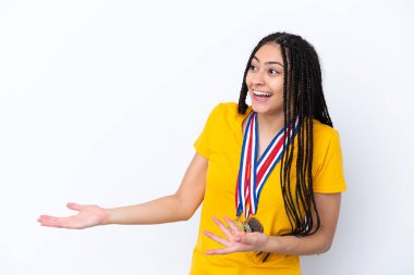 Saç örgüleri ve madalyaları olan genç bir kız izole edilmiş pembe bir arka plan ve şaşırtıcı bir yüz ifadesi var.