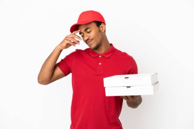 Afro-Amerikalı pizzacı, izole edilmiş beyaz duvardan pizza kutuları alıp gülüyor.