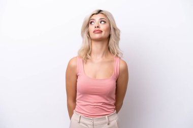 Beyaz arka planda izole edilmiş genç bir Rus kadın yukarı bakarken şüphe duyuyor.