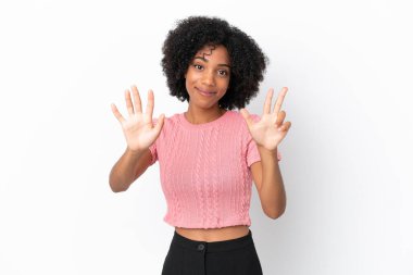 Beyaz arka planda izole edilmiş genç Afrikalı Amerikalı kadın parmaklarıyla sekiz sayıyor.