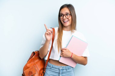 Mavi arka planda izole edilmiş genç bir bayan parmak kaldırarak çözümü anlamaya çalışıyor.