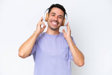 Soyutlanmış beyaz arka planda müzik dinleyen yakışıklı bir adam.