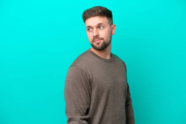 Mavi arka planda izole edilmiş genç beyaz bir adam. Portre