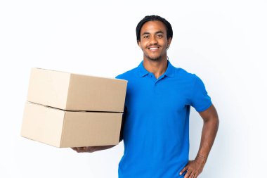 Beyaz arka planda izole edilmiş, kolları kalçasında poz veren ve gülümseyen Afrikalı Amerikalı bir adam.