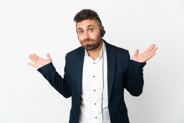 Beyaz arka planda izole edilmiş bir kulaklıkla çalışan pazarlamacı el kaldırırken şüpheye düşüyor.