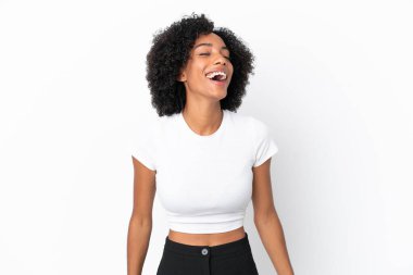 Genç Afrikalı Amerikalı kadın beyaz arka planda yalnız gülüyor.