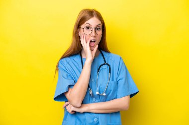Sarı arka planda izole edilmiş genç kızıl saçlı hemşire sağa bakarken şaşırmış ve şok olmuştu.