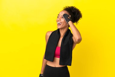 Sarı arka planda izole edilmiş genç Afrikalı spor kadını bir şey fark etti ve çözüme niyetlendi.