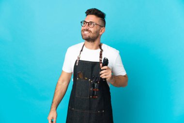 Önlüklü bir berber yukarı bakarken bir fikir düşünüyor.