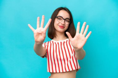 Mavi arka planda izole edilmiş genç Ukraynalı kadın parmaklarıyla dokuz kişi sayıyor.