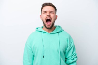Beyaz arka planda izole edilmiş genç beyaz bir adam ağzı açık bir şekilde öne doğru bağırıyor.