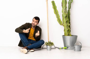 Bahçıvan içeride yerde oturmuş para jesti yapıyor ama mahvolmuş.