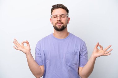 Beyaz arka planda Zen pozisyonunda beyaz tenli genç bir adam