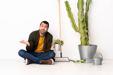 Bahçıvan içeride yerde oturuyor. Şüpheci hareketler yapıyor.