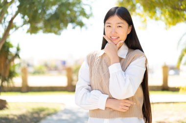 Dışarıdaki güzel Çinli kadın gülümsüyor.