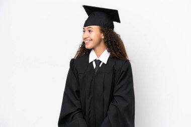 Üniversite mezunu genç bir Arap kadın, beyaz arka planda izole bir şekilde gülüyor.