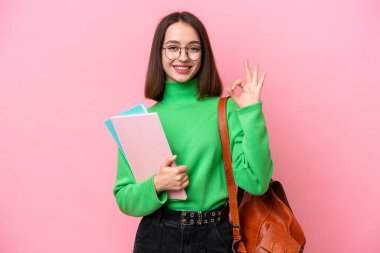 Pembe arka planda izole edilmiş genç Ukraynalı kadın parmaklarıyla işaret veriyor.