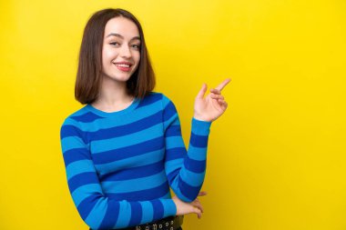 Sarı arka planda izole edilmiş genç Ukraynalı bir kadın parmak işareti yapıyor.
