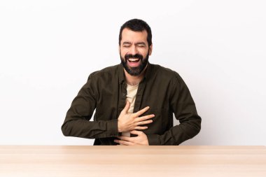 Masada sakallı, beyaz bir adam gülümsüyor..