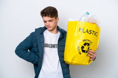 Beyaz arka planda geri dönüşüm yapmak için elinde plastik şişelerle dolu bir çanta tutan Rus ergen, çaba sarf ettiği için sırt ağrısı çekiyor.