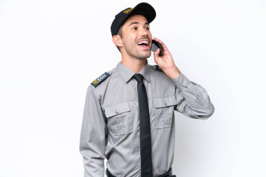 İzole edilmiş beyaz arka planda genç bir güvenlik görevlisi cep telefonuyla sohbet ediyor.