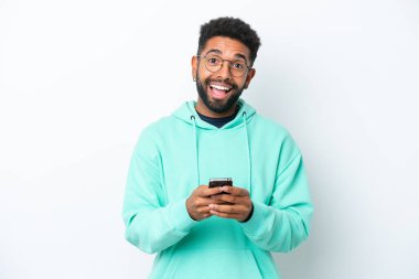 Beyaz arka planda izole edilmiş genç Brezilyalı bir adam şaşırdı ve bir mesaj gönderiyor.