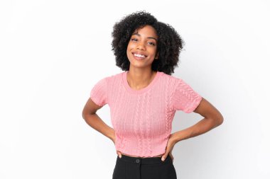 Beyaz arka planda izole edilmiş genç Afrikalı Amerikalı kadın kolları kalçasında ve gülümsüyor.