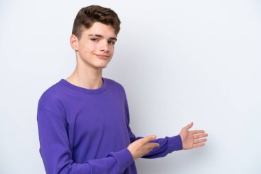 Beyaz arka planda izole edilmiş genç bir Rus adam davet edilmek için ellerini yana uzatıyor.