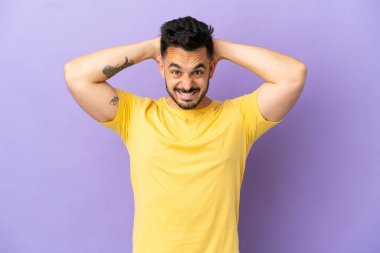 Mor arka planda izole edilmiş genç beyaz adam gergin hareketler yapıyor.