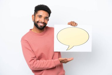 Genç Brezilyalı bir adam beyaz arka planda izole edilmiş. Elinde konuşma balonu ikonu olan bir levha var.