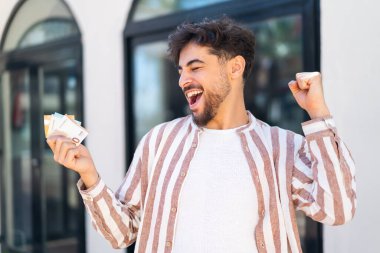 Dışarıdaki yakışıklı Arap çok para alıyor ve zaferi kutluyor.