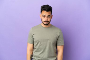 Morarmış arka planda, üzgün bir ifadeyle izole edilmiş genç beyaz bir adam.