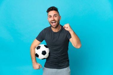 Futbolcu mavi arka planda tek başına galibiyeti kutluyor.
