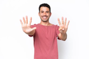 Soyutlanmış beyaz arka planda genç yakışıklı adam parmaklarıyla dokuz sayıyor.