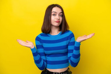 Sarı arka planda izole edilmiş genç Ukraynalı kadın şüpheli hareketler yapıyor.