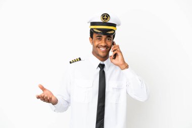 İzole edilmiş beyaz arka plan üzerinde Afrikalı Amerikan Uçak Pilotu cep telefonuyla sohbet ediyor.