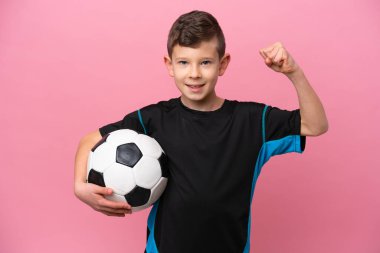 Pembe arka planda izole edilmiş beyaz futbolcu çocuk güçlü bir jest yapıyor.
