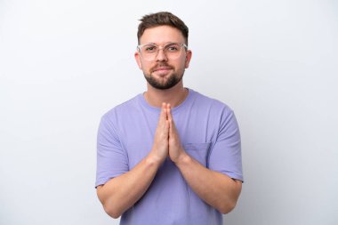 Beyaz arka planda izole genç beyaz adam avuç içlerini bir arada tutuyor. İnsan bir şey ister.