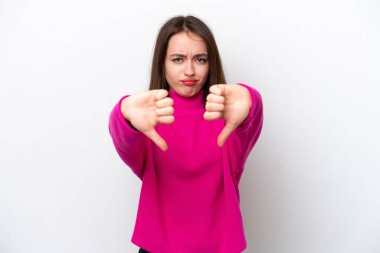 Beyaz arka planda izole edilmiş genç Ukraynalı kadın baş parmağını iki eliyle aşağı gösteriyor.