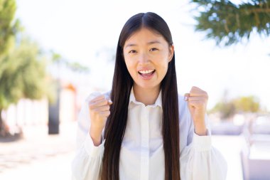 Güzel Çinli kadın dışarıda galibiyetini kutluyor.