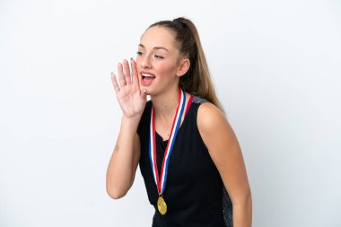 Young caucasian woman with medals isolated on white background shouting with mouth wide open to the lateral