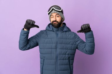 Kar kayağı gözlüklü kayakçı mor arka planda gururlu ve kendini beğenmiş.